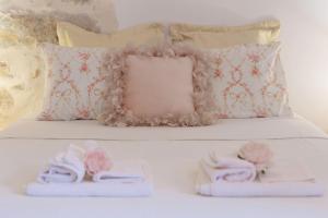 - un lit avec deux serviettes et une paire de chaussons dans l'établissement Iliana's house - spacious cave house in the center of Areopolis, à Areópoli
