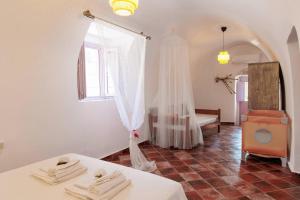 Cette chambre blanche dispose d'un lit et d'une fenêtre. dans l'établissement Iliana's house - spacious cave house in the center of Areopolis, à Areópoli