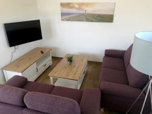 a living room with a couch and a tv at Seehaus Luddenhof 1 - a90196 in Walchum