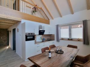 a kitchen and dining room with a wooden table at WellnessOase Hafenblick - a90190 in Walchum