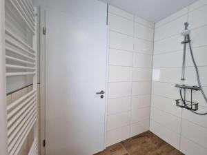 a bathroom with a shower with white tiles at Ferienwohnung Angela - a90191 in Walchum