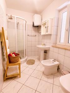 a white bathroom with a toilet and a sink at Apartments Villa Marijeta with Free Parking in Zaton