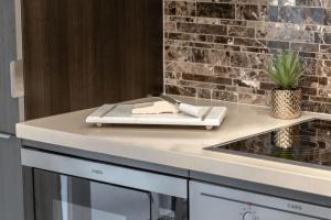 a kitchen with a counter with a stove top oven at Stunning 1BR and Den Sleeps 6 Steps From CN Tower in Toronto +50 photos