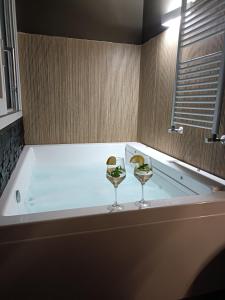 SOHO B&B في فيشانو: كأسين من النبيذ يجلسون فوق حوض الاستحمام