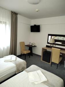 a hotel room with two beds and a desk and a piano at Hotel Eljot in Sielpia Wielka