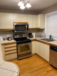 金斯頓的住宿－Comfy Room Stay - Unit 1，厨房配有炉灶和微波炉。