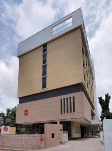 浦那Spree Shivai Hotel Pune的一座高大的建筑,上面有红色的标志
