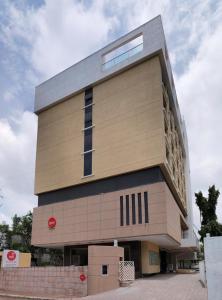 un edificio alto con una señal roja. en Spree Shivai Hotel Pune, en Pune