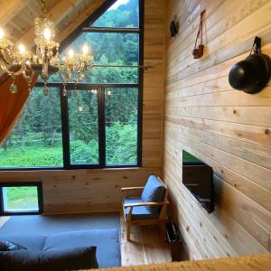 a living room with a large window in a log cabin at Nanus Ayder Bungalow and Breakfast in Çamlıhemşin