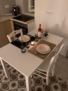 諾奇的住宿－Nonna Lenuccia，一张带两把椅子的白色桌子和一瓶葡萄酒