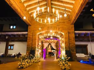 un salón de banquetes con un arco de boda y flores en Visus Hotel Boutique & Spa en Pereira