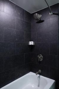 baño de azulejos negros con lavabo y ducha en Renaissance Chicago North Shore Hotel en Northbrook