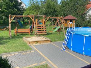 un parque infantil con piscina y columpio en Agroturystyka Barzowice en Darłowo
