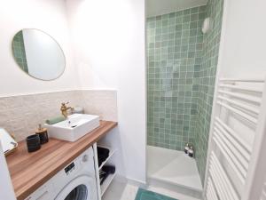 a bathroom with a sink and a washing machine at Appartement Spacieux avec Parking proche MER in Saint-Nazaire +12 photos