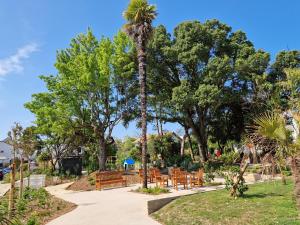 a park with benches and a palm tree at Appartement Spacieux avec Parking proche MER in Saint-Nazaire