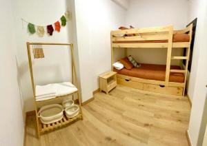 a small room with two bunk beds and a wooden floor at Apartamento Brisas in Moaña
