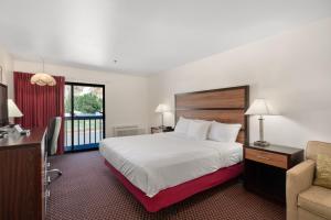 um quarto de hotel com uma cama e uma cadeira em Wedge Mountain Inn em Leavenworth