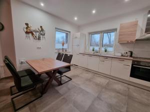 a kitchen with a wooden table and chairs in a room at Ferienhaus Seebrise - a90185 in Walchum