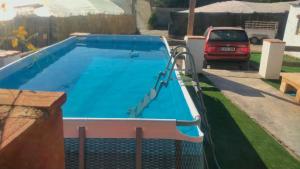 uma piscina num quintal com um carro estacionado ao lado em Casa de campo Espinosa em La Garnatilla