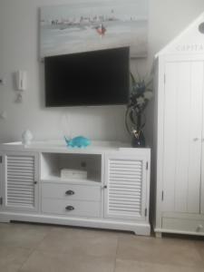 a white entertainment center with a flat screen tv on a wall at Il gelsomino in Fano