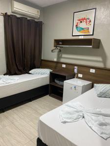 a hotel room with two beds and a window at Hotel Novo Santa Cruz in Sao Paulo