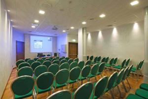 a conference room with green chairs and a projection screen at Hotel Iris in Genoa