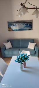 un soggiorno con tavolo bianco e divano blu di Il Tulipano a Sorrento