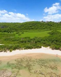 an aerial view of a beach and a green field at Villa Del Carmen Family Vacation Home in Isabela