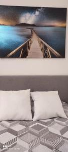 a bed with two pillows and a painting of a bridge at Il Tulipano in Sorrento