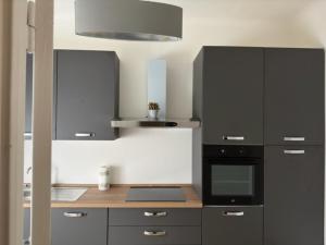 a kitchen with a black oven and a stove at Appartamenti Monti Como Lake in Brunate