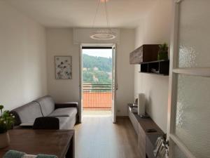 a living room with a couch and a table and a window at Appartamenti Monti Como Lake in Brunate