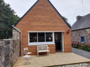 ein Haus mit einer Terrasse mit 2 Stühlen und einem Fenster in der Unterkunft Le cottage in Crozon
