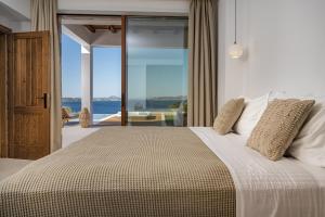 a bedroom with a bed with a view of the ocean at Thesan Villas in Marathias