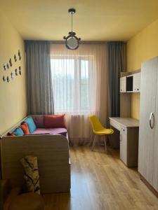 a bedroom with a bed and a desk with a yellow chair at TREFOIL in Lori Berd