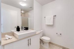 a white bathroom with a sink and a toilet at Cozy Downtown 2BR Suite near CN Tower with Balcony in Toronto +16 photos
