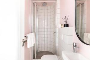 a bathroom with a toilet and a sink and a mirror at Sweet Flamingo in Cape Town