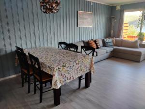 uma sala de estar com uma mesa com cadeiras e um sofá em FeelHome 3 bedroom Near University em Tromsø