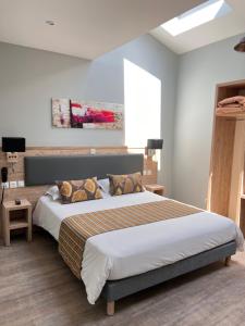 een slaapkamer met een groot bed in een kamer bij Hôtel La Pinède in Soulac-sur-Mer