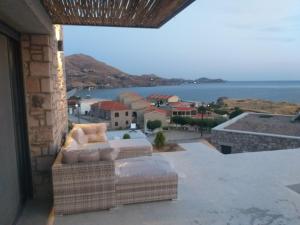 a balcony with a couch and a view of the ocean at Villa la Vago in Agios Ioannis Kaspaka