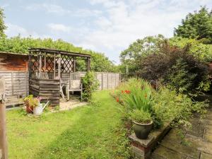 un jardin avec un banc et quelques plantes dans l'établissement Deer Cottage, à Thompson