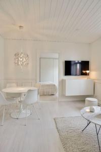 - un salon blanc avec une table et des chaises dans l'établissement Apartment Wilma, à Aalborg