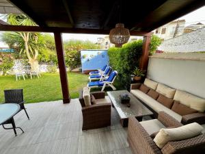 un patio con divano, sedie e tavolo di Beach and Golf House La Cala de Mijas a La Cala de Mijas