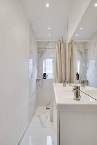 La salle de bains blanche est pourvue d'un lavabo et d'une douche. dans l'établissement Apartment Wilma, à Aalborg