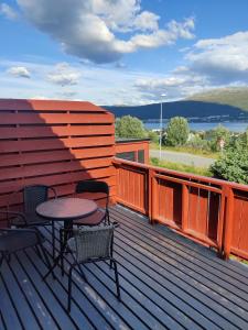 patio con tavolo e sedie su una terrazza di FeelHome 3 bedroom Near University a Tromsø