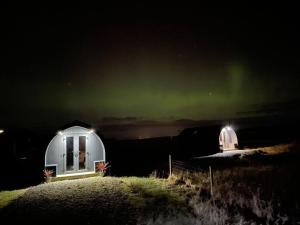 a couple of observatories with the aurora in the sky at Croisgeir Self Catering Pod in Daliburgh