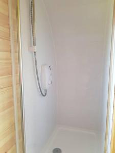 y baño con ducha y puerta de cristal. en Croisgeir Self Catering Pod, en Daliburgh