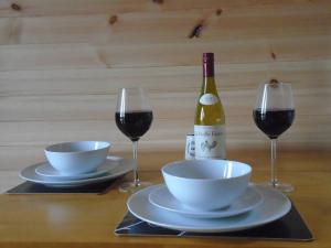 una mesa con dos copas de vino y una botella de vino en Croisgeir Self Catering Pod, en Daliburgh