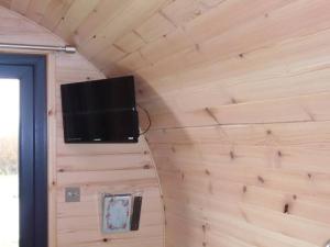 TV de pantalla plana en la pared de una habitación en Croisgeir Self Catering Pod, en Daliburgh