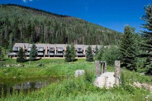 a large building in a field next to a mountain at Cascade Village 301 in Durango Mountain Resort
