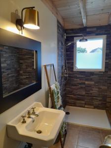 a bathroom with a sink and a bath tub at Le cottage in Crozon